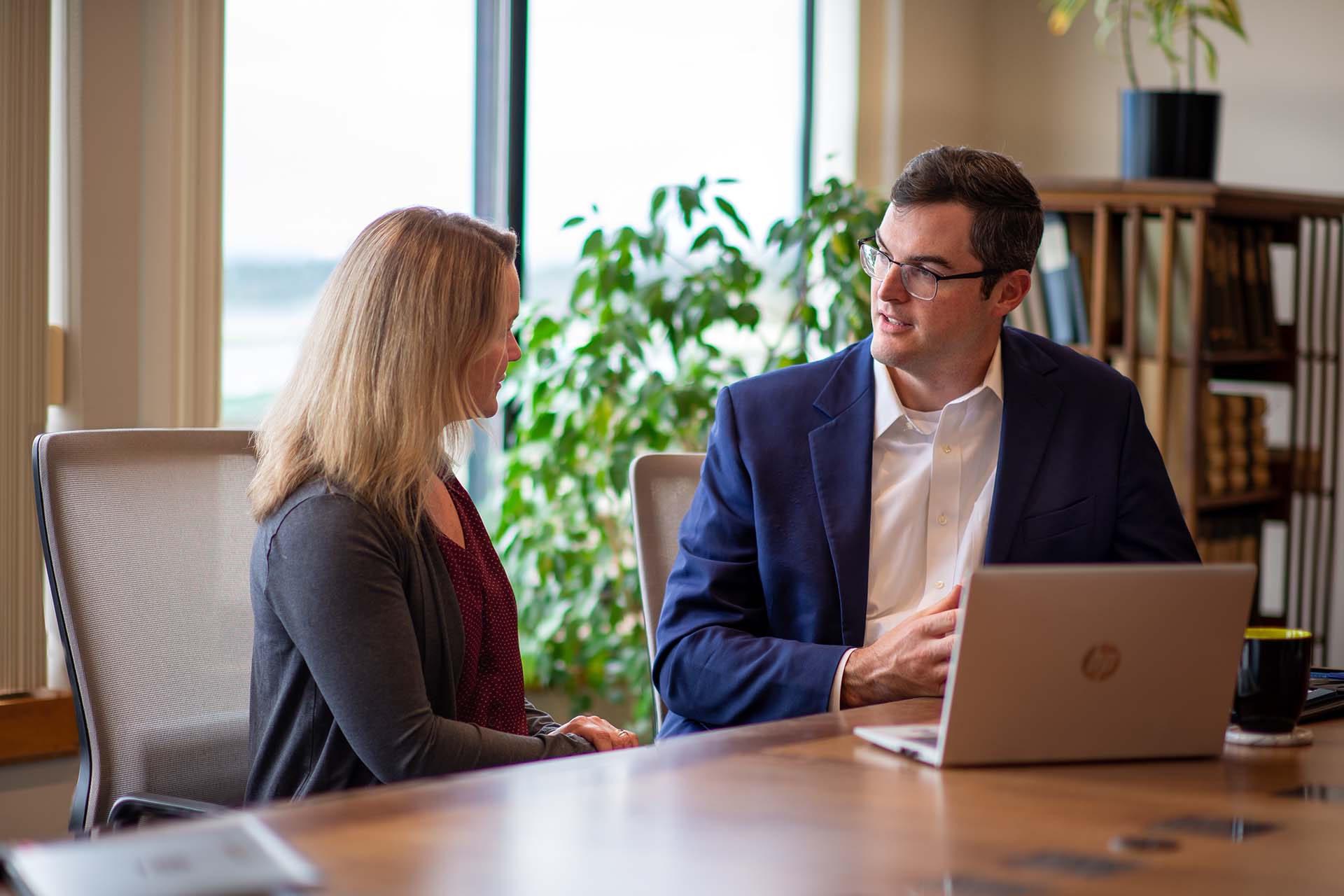 2 people sitting at a table discussing business during a meeting