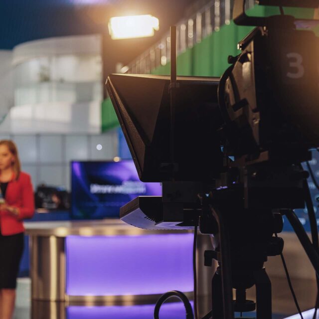 broadcast camera recording news anchor in studio