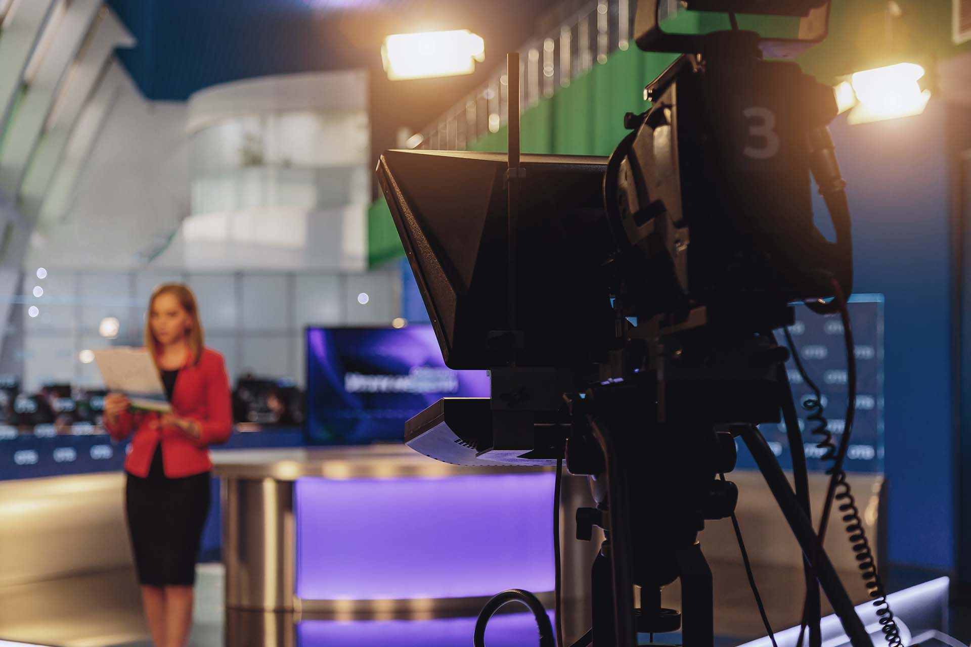 broadcast camera recording news anchor in studio