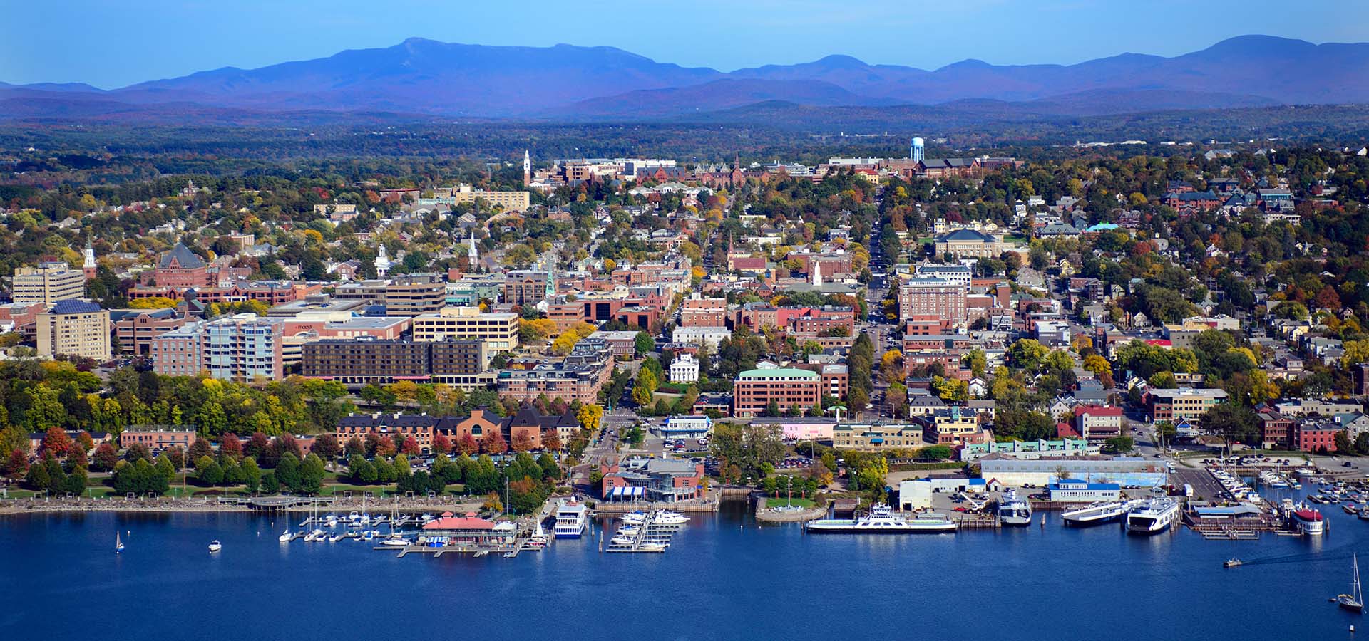 aerial view of waterfront in Burlington, VT with mountains in the background