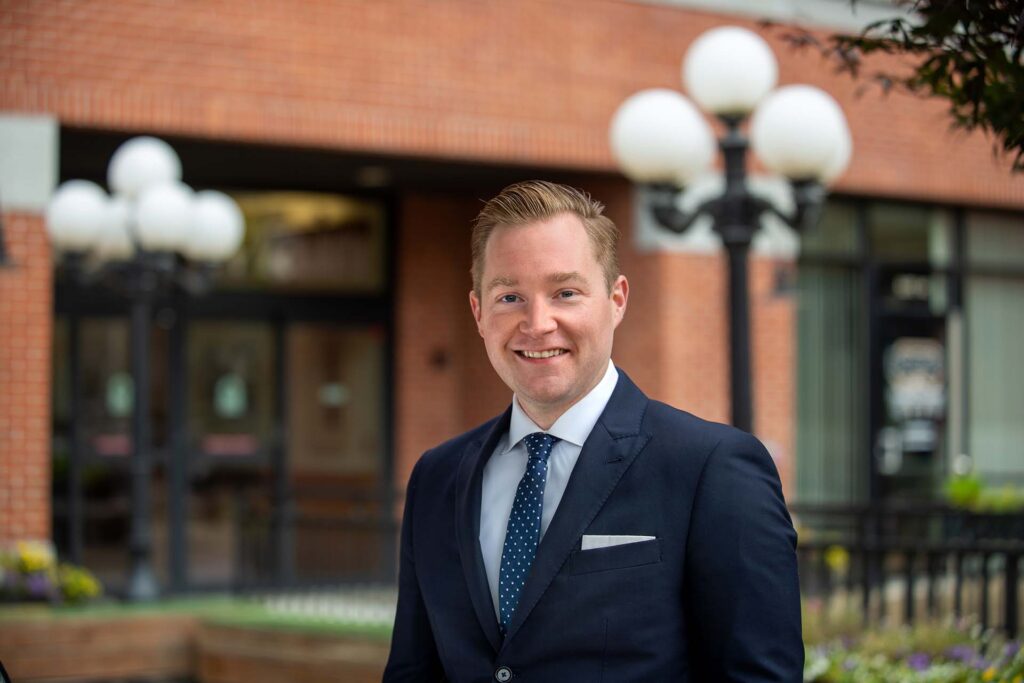 attorney in suit smiling in front of brick building