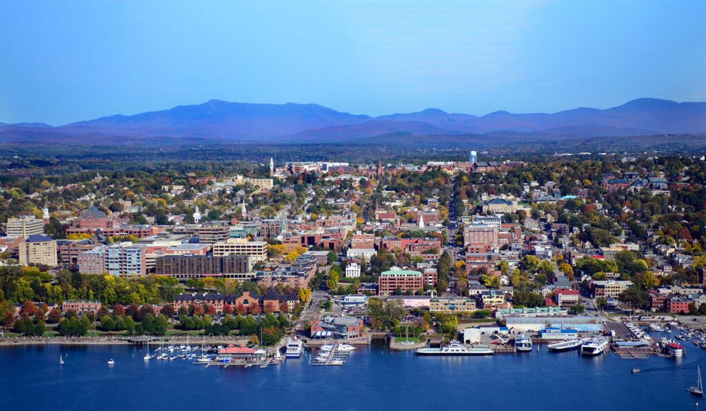 aerial view of waterfront in Burlington, VT with mountains in the background